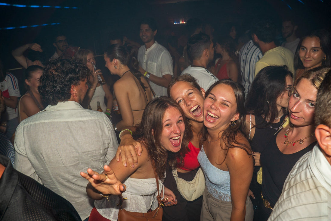 Group of young travelers laughing and celebrating together on a packed dance floor during a high energy bar crawl in Nice capturing intense party vibes and unforgettable nightlife moments in the French Riviera