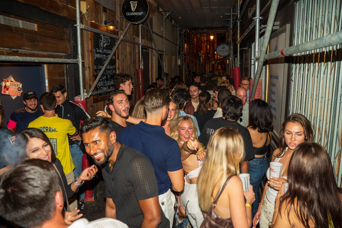 Crowded street scene with international travelers socializing between bars during a bar crawl in Nice showing the lively nightlife atmosphere and first time bar crawl experience in the French Riviera