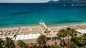 Beach club party in Cannes by the sea with DJ and dancing crowd on the French Riviera