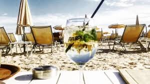 Beach party in Cannes with DJ booth bonfire and crowd dancing on the sand