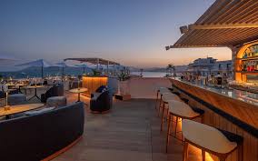 Rooftop bar in Cannes with panoramic view of the French Riviera and cocktail at sunset