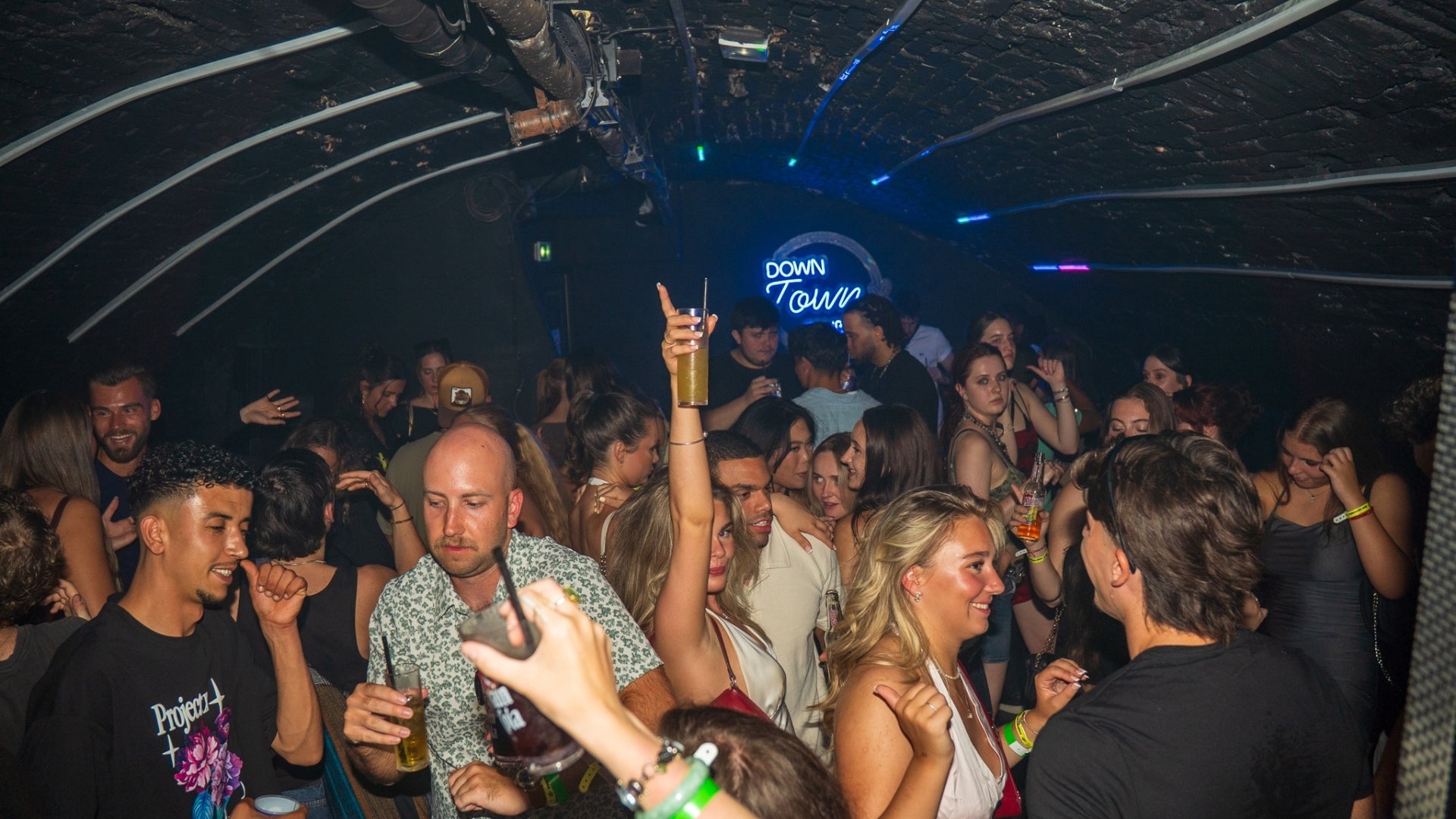 Energetic nightlife atmosphere during the Nice Bar Crawl Orange with drinks music and social interactions